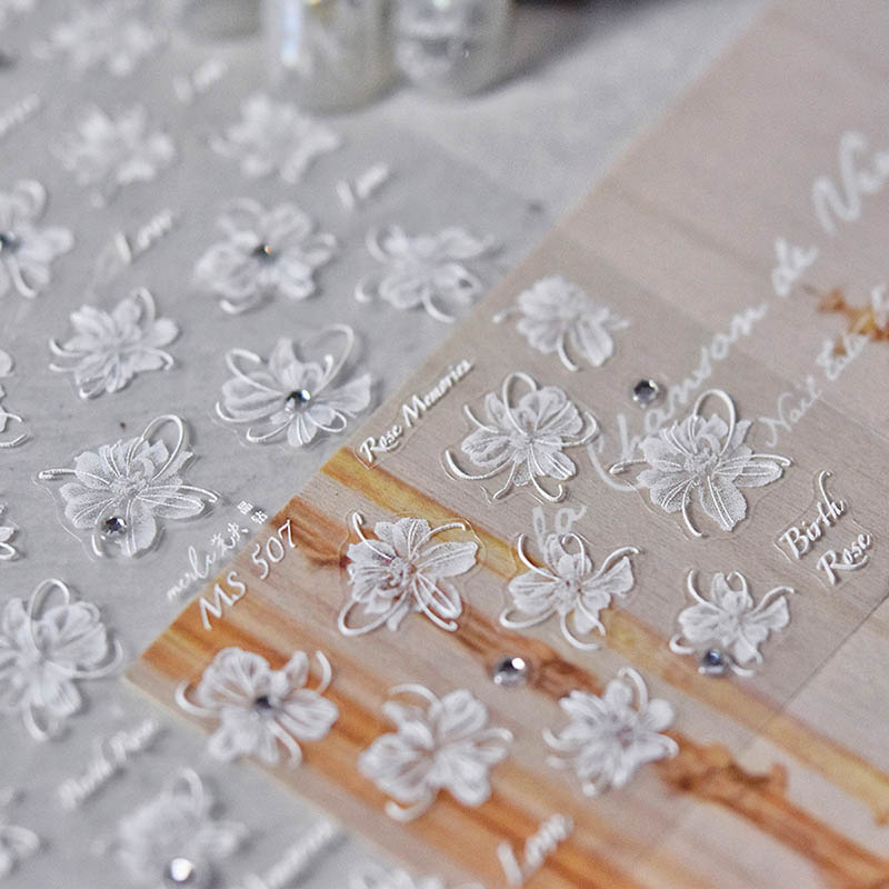 White flower nail sticker with crystal accents and detailed blossom