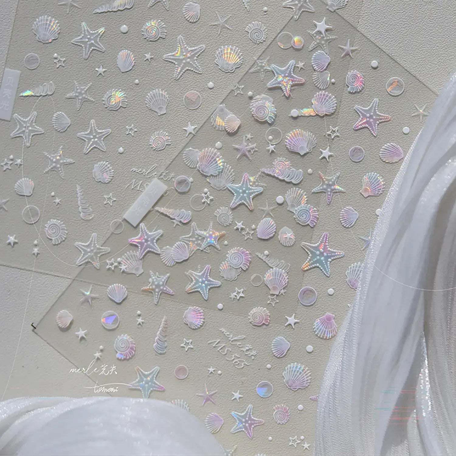 Seashell and star-shaped stickers on a light gray background