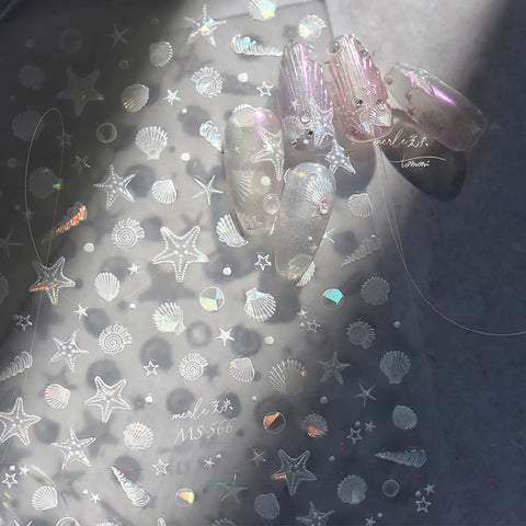 Translucent nail art sheet with starfish, shell, and mermaid-themed designs on a gray background.